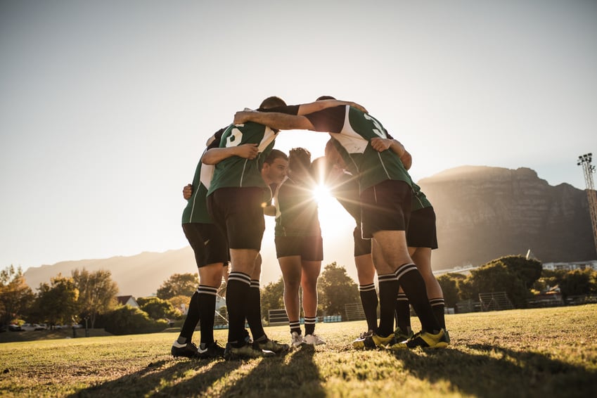 Rugby Players Huddling on Sports Field